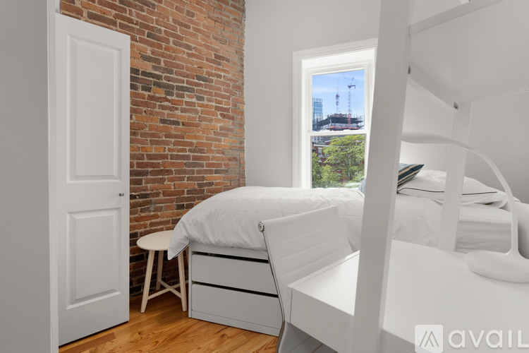A white chair with wheels is in a room with a brick wall.