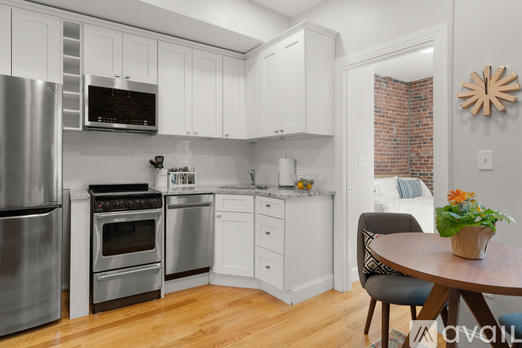 A kitchen with white cabinets and a wooden table.