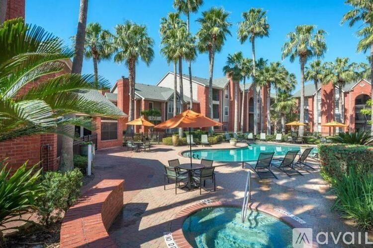 A pool surrounded by palm trees and lounge chairs.