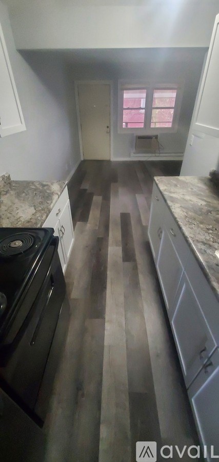 A kitchen with a black stove top oven and white cabinets.