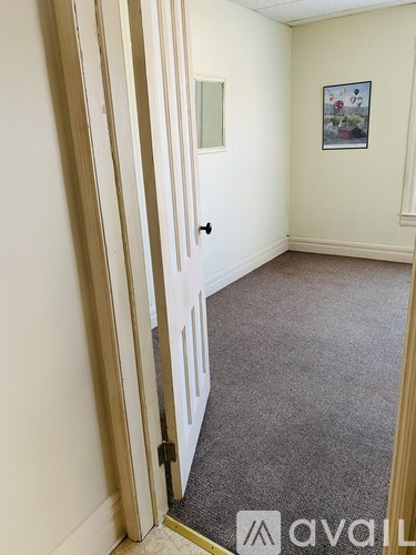 A room with a carpeted floor and a door.