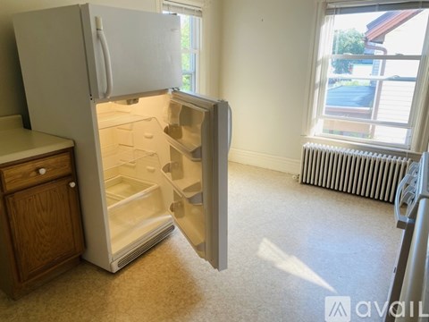 A white refrigerator with its door open in a room.