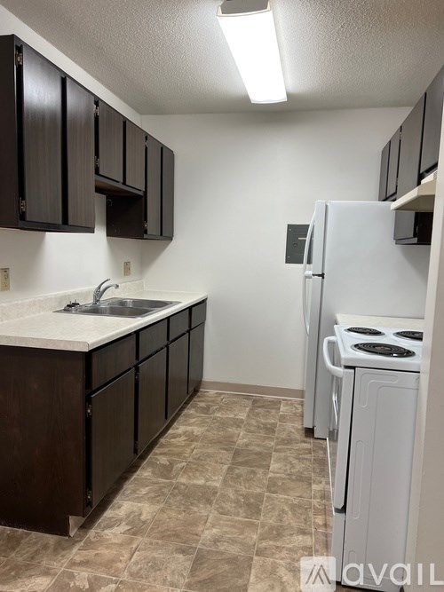 A kitchen with brown cabinets and a white stove.