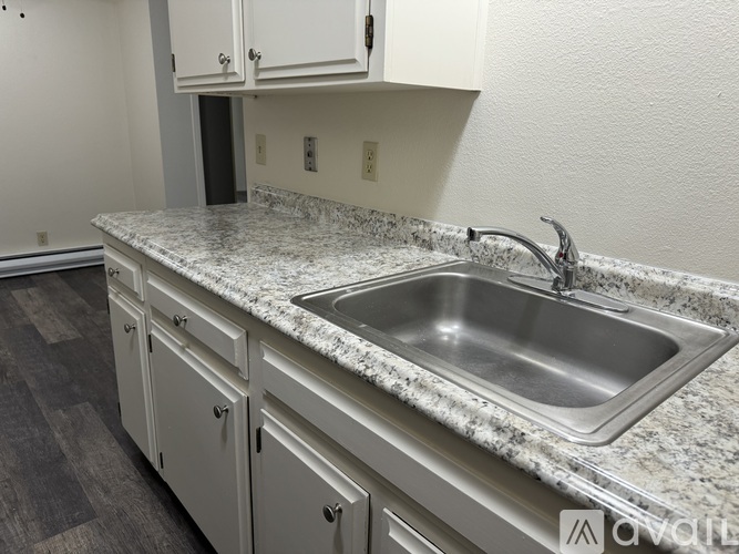 A kitchen with a granite countertop and a stainless steel sink.