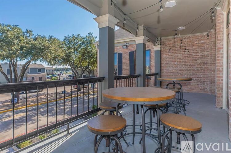 A patio with a table and chairs overlooking a street.