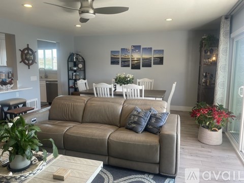 A living room with a grey couch and a ceiling fan.