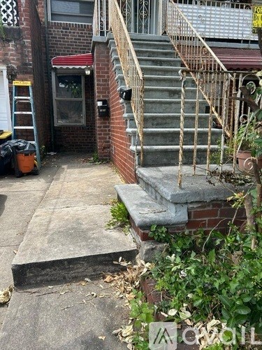 A brick house with a staircase leading to a door.