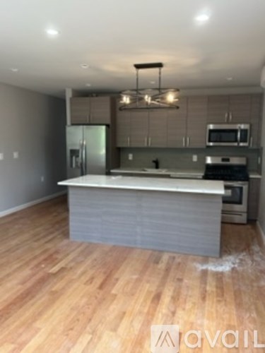 A kitchen with a wooden floor and a white counter.