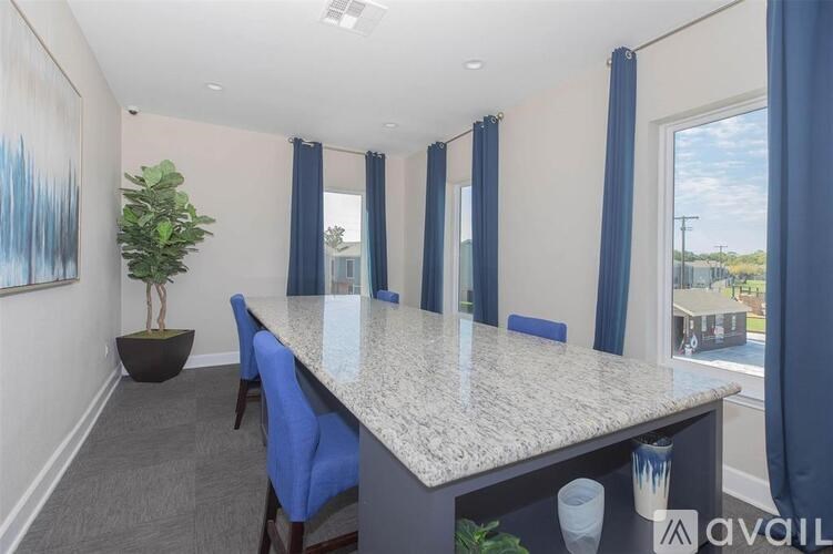 A room with a large table and blue chairs.