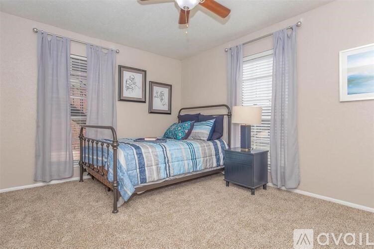 A bedroom with a bed, nightstand, and a ceiling fan.