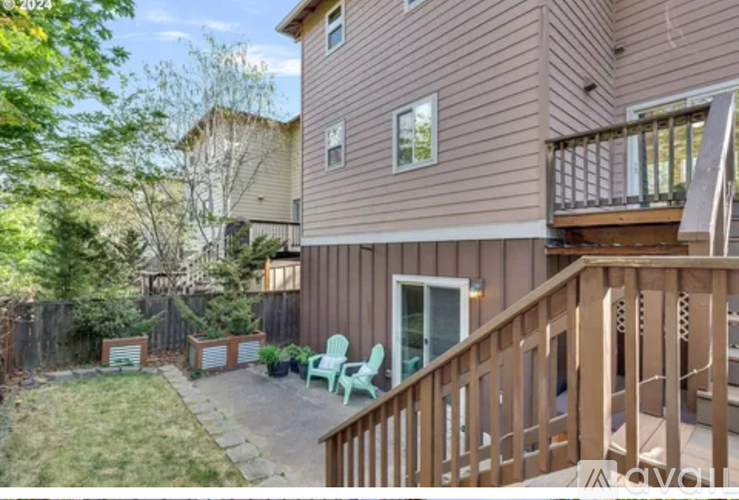 A brown house with a green chair and a wooden deck.