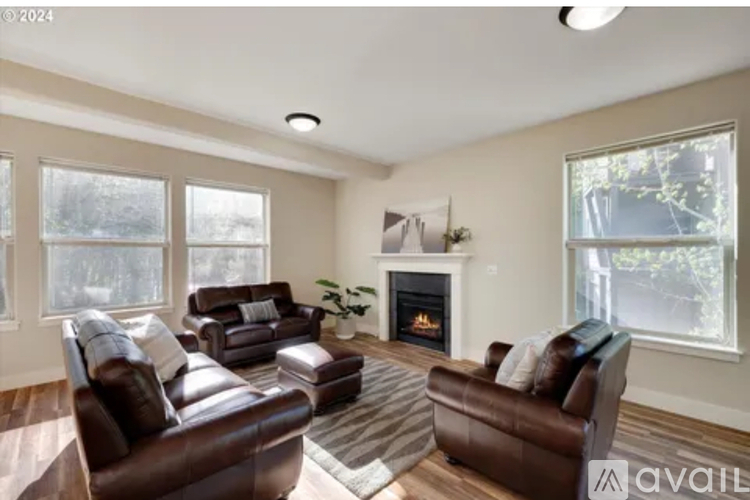 A living room with brown leather furniture and a fireplace.