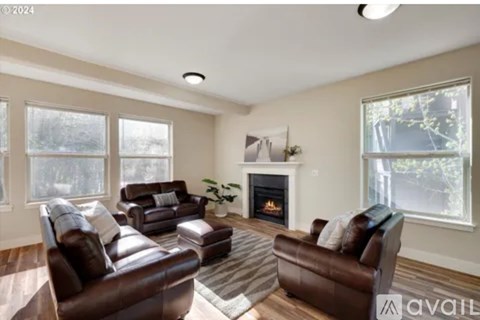 A living room with brown leather furniture and a fireplace.