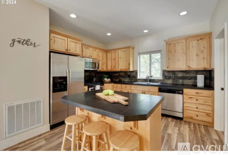 A kitchen with wooden cabinets and a black countertop.