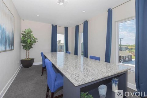 A room with a large table and blue chairs.