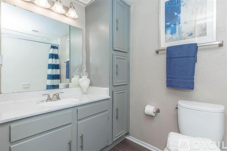 A bathroom with a white sink and a white toilet.