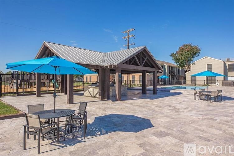 A patio area with tables and chairs and umbrellas.