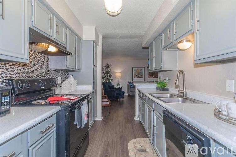A kitchen with a black stove top oven and a black dishwasher.