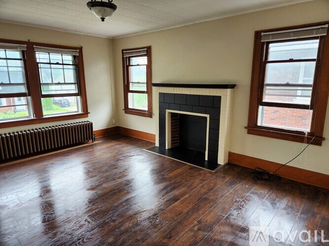 A room with a fireplace and wood flooring.