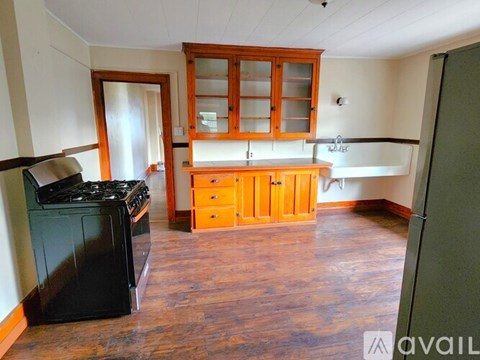 A kitchen with wooden cabinets and a black stove top oven.