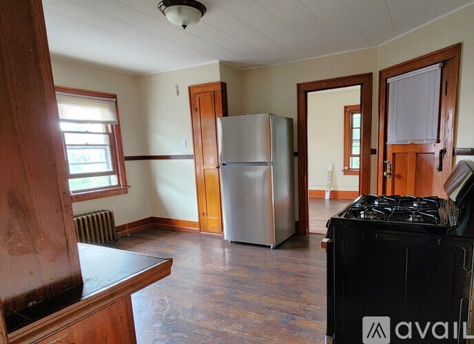 A kitchen with a stove, refrigerator, and cabinets.
