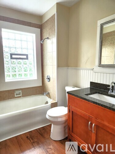 A bathroom with a toilet, sink, and bathtub.