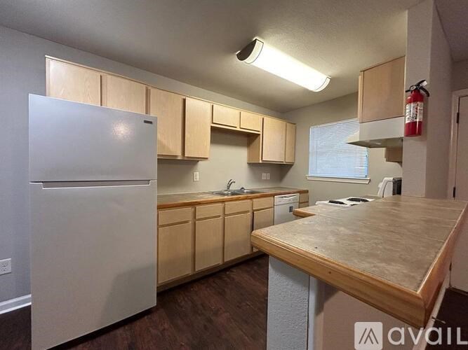 A kitchen with a white refrigerator and wooden countertops.