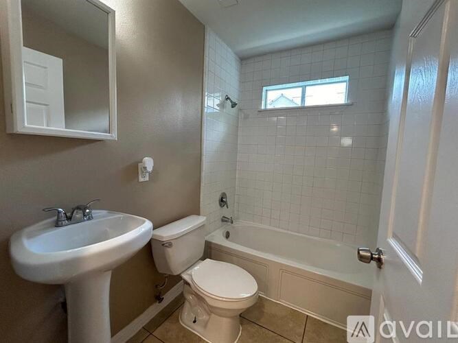 A bathroom with a toilet, sink, and bathtub.