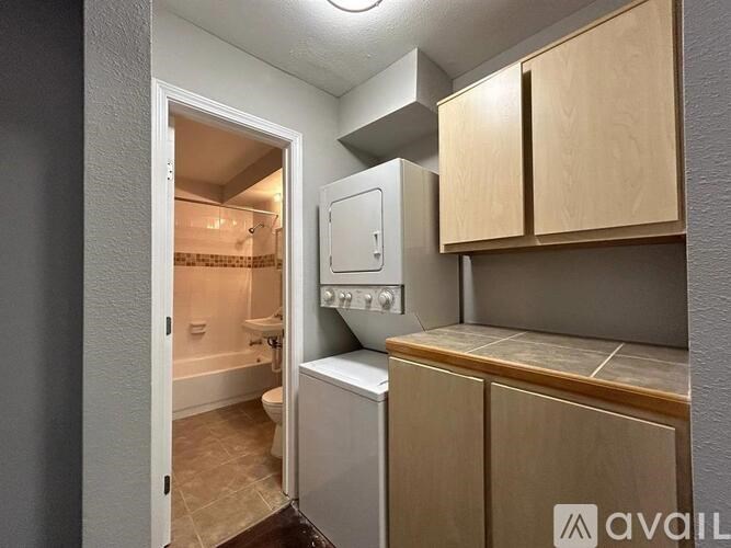 A small bathroom with a toilet, sink, and cabinets.