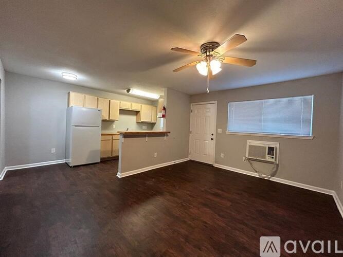 A room with a ceiling fan and a window with blinds.
