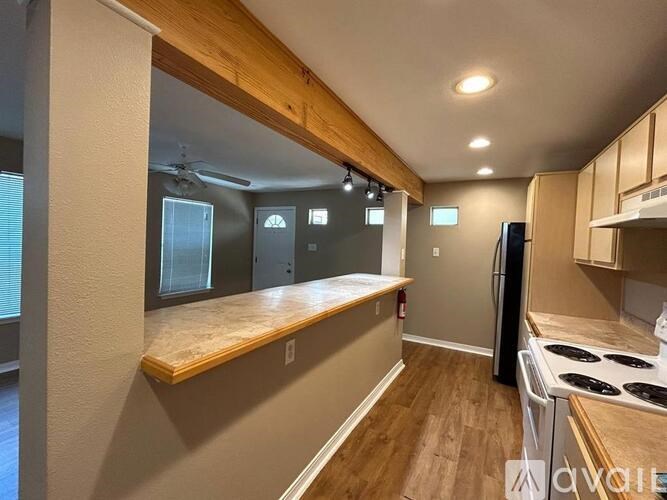 A kitchen with a stove top oven and a refrigerator.
