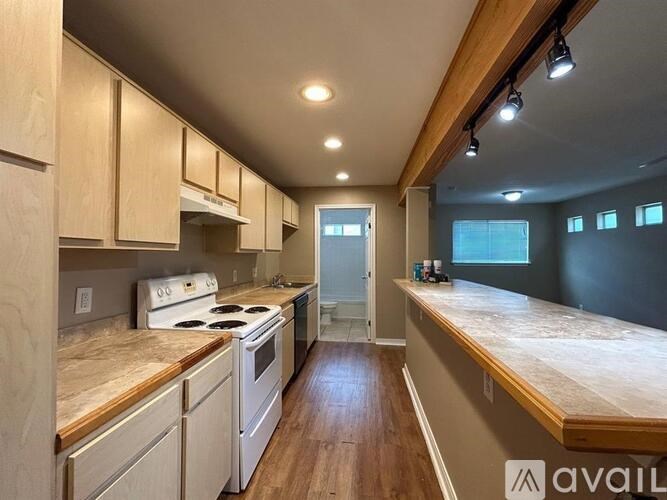 A kitchen with wooden cabinets and a white stove top oven.