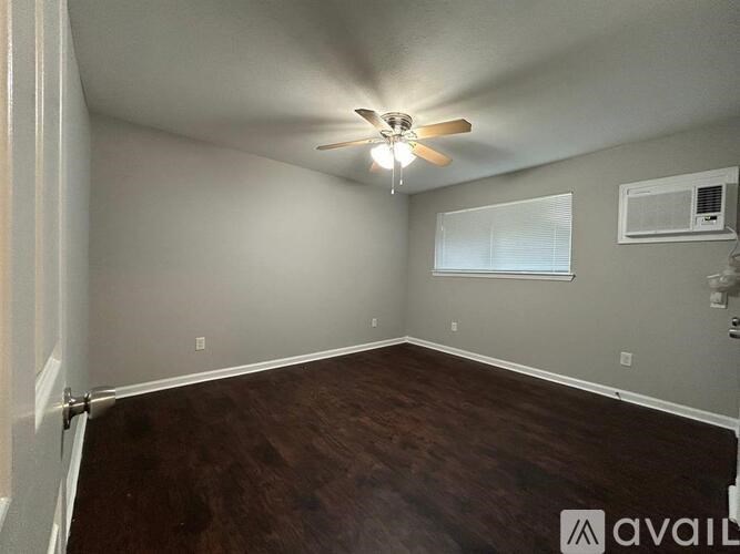 A room with a ceiling fan and wooden flooring.
