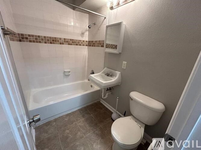 A white toilet sits next to a bathtub in a bathroom.