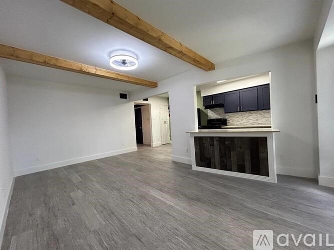 A spacious room with wooden beams and a window seat.