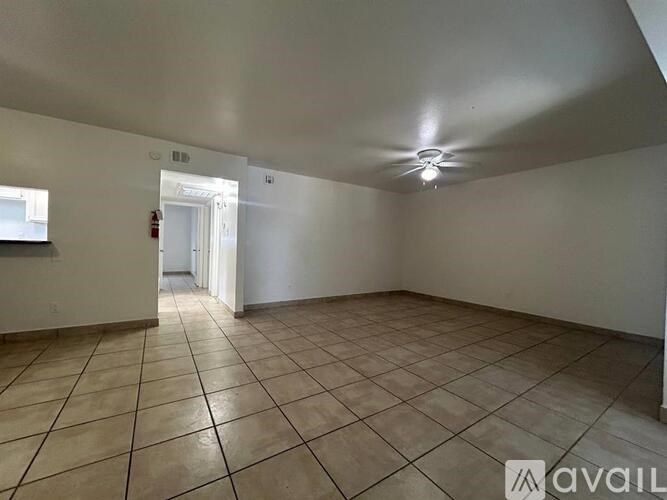 A spacious room with tiled flooring and a ceiling fan.