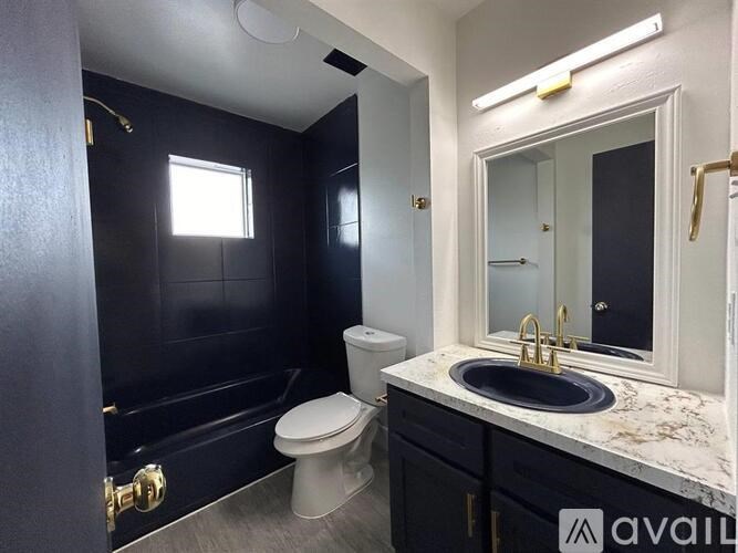 A bathroom with a black shower stall and a white toilet.