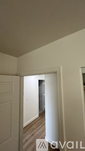 A hallway with a door on the left and a door on the right.