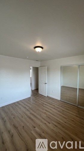 A room with wooden flooring and a white door.