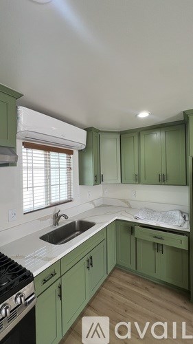 A kitchen with green cabinets and a stove top oven.