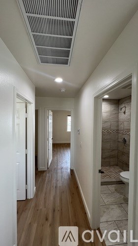 A long hallway with a shower area on the right.
