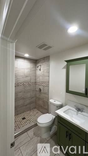 A bathroom with a toilet, sink, and shower.