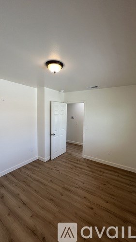 A room with a wooden floor and a white door.
