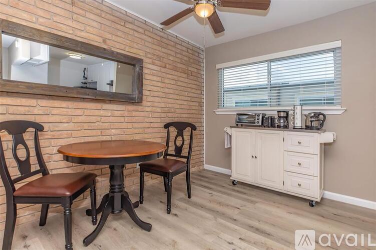 A dining area with a round wooden table and chairs.