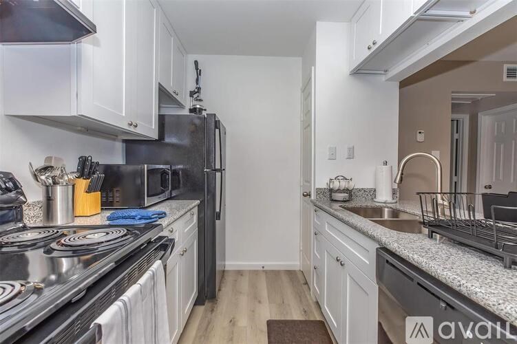 A kitchen with white cabinets and a black stove top.