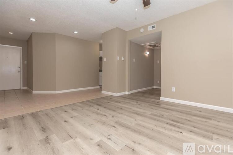 A spacious room with wooden flooring and beige walls.