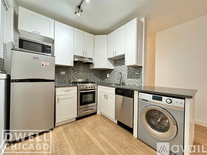 A kitchen with white cabinets and stainless steel appliances.