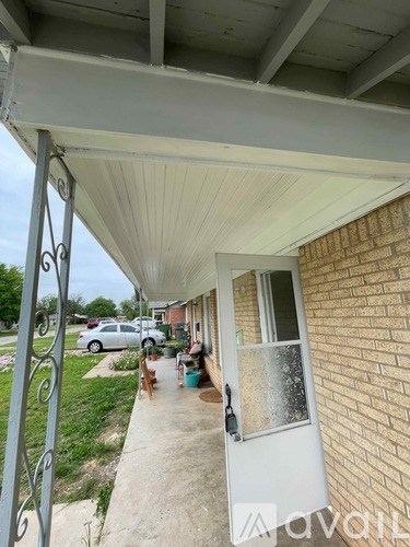A white door is on the right side of a brick building.