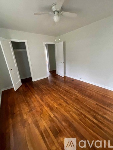 A room with wooden floors and two open doors.