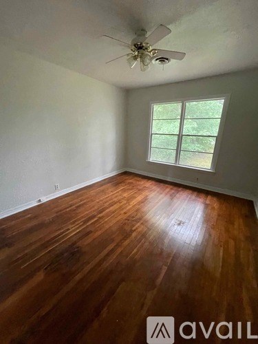 A room with wooden floors and a ceiling fan.